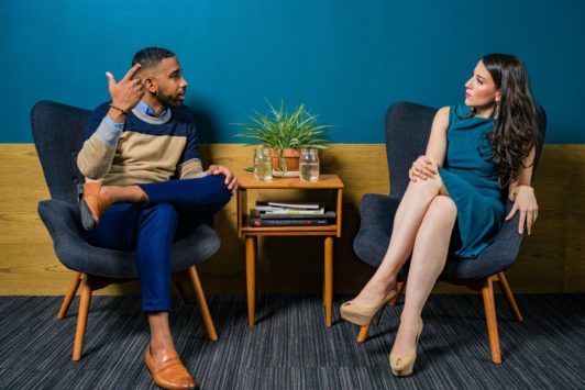 a man and woman discussing how to become a social worker while sitting in chairs