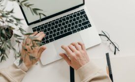 a person engaged in typing on a laptop, focused on an affiliate marketing course