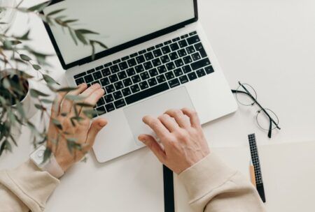 a person engaged in typing on a laptop, focused on an affiliate marketing course