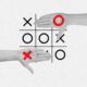 hands displaying a tic tac toe board designed with a python theme