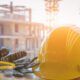 A cartoon construction worker promotes health and safety in construction, wearing a hard hat and safety glasses.