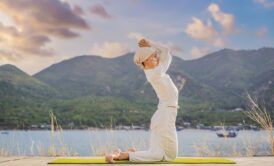A woman performing Kundalini yoga by a tranquil lake
