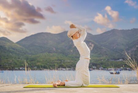 A woman performing Kundalini yoga by a tranquil lake