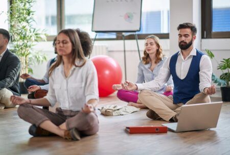 Group meditation session in a yoga class, promoting calmness and stress relief.