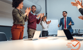a group of business professionals clapping in a meeting room to show appreciation in the workplace