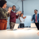 a group of business professionals clapping in a meeting room to show appreciation in the workplace