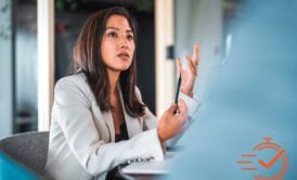 A woman in a business suit giving advice on how to be more assertive.