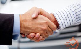 handshake between two people in front of a car, representing the secrets of closing the sale