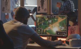 a man sitting at a desk with a computer screen, working on unity game development