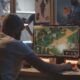 a man sitting at a desk with a computer screen, working on unity game development