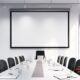 A spacious conference room with a big screen and chairs, perfect for conducting meetings and brainstorming sessions.