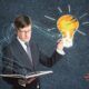 man in suit with book and light bulb, representing creativity and innovation