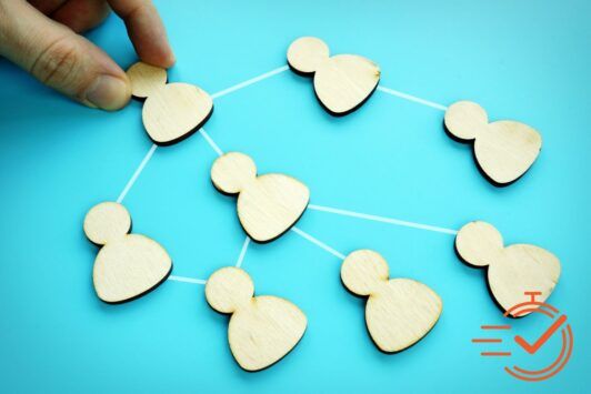 Demonstrating delegation skills with wooden figures on blue background.