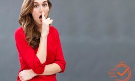 A woman gestures for quiet with her finger on her lips, emphasizing the importance of discretion.