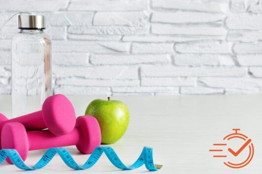 A bottle of water, a dumbbell, and an apple, showcasing key elements of health and wellness for a fit lifestyle.