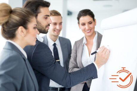 business professionals in a positive training environment, attentively gathered around a whiteboard for a meeting