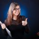 Woman with glasses and tablet giving thumbs up, showing positive attitude for ways to improve mindset.
