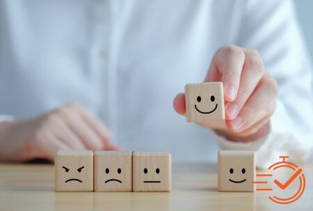 A person displays wooden blocks featuring smiley faces, highlighting a creative method for enhancing customer experience training