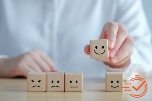 A person displays wooden blocks featuring smiley faces, highlighting a creative method for enhancing customer experience training