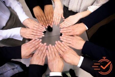 diverse business team forming a circle with hands together, representing engaging your people in the workplace