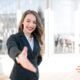 A confident woman in a business suit extends her hand, symbolizing leadership and new beginnings in the workplace.