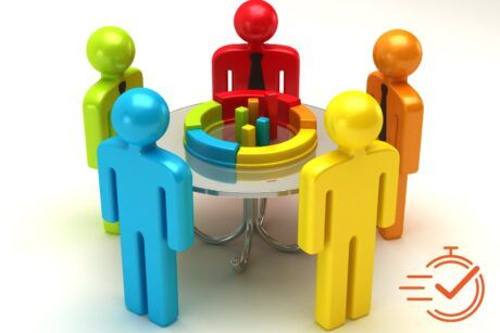 A group of people engaged in a training session, discussing a pie chart around a table