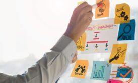 A businessman brainstorming on sticky notes on a whiteboard, highlighting strategies from the best project management course.