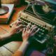 a person engaged in typing on an old typewriter, reflecting on their memoir writing course experience