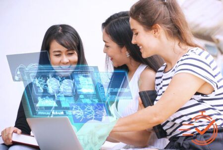 Three women collaborating over a laptop, exploring AI in the workplace together.