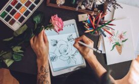 an artist is engaged in drawing a flower on a tablet, utilizing Procreate Dreams to express her artistic vision