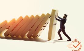 A man pushes a tower of dominos during a crisis management training session, illustrating the impact of decisions.