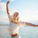 a woman in jeans and a white shirt gazes at the lake, reflecting on how to get superpowers​ for life and happiness