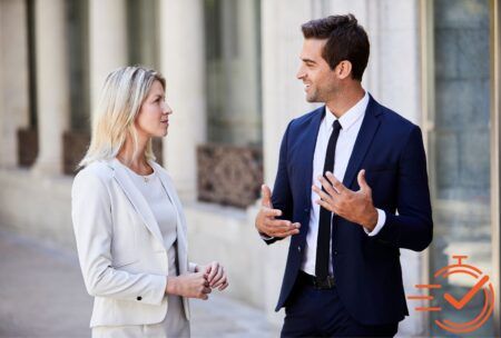 a man and woman in business attire engage in a conversation, highlighting barriers of communication