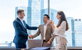two business individuals shaking hands in an office, illustrating the art of persuasion in professional relationships