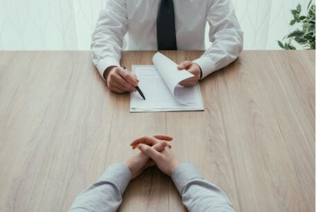 Two gentlemen wearing a shirt and tie sitting face-to-face each other. How to get a job fast
