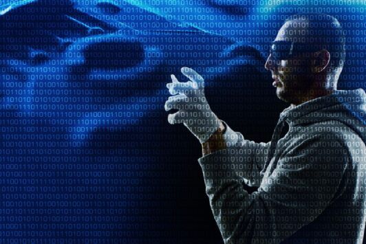 A man in a hoodie and gloves stands confidently, embodying the basics of ethical hacking.