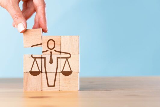 a wooden block with a justice symbol illustrating the role of ethics in a digital transformation framework