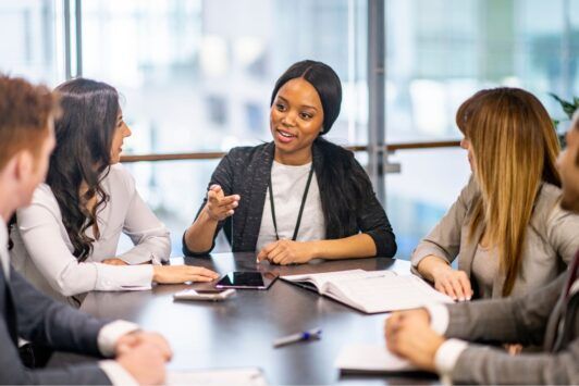 a woman in a business suit engages in discussion with her team, emphasizing the disciplines of execution in their conversation
