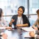 a woman in a business suit engages in discussion with her team, emphasizing the disciplines of execution in their conversation
