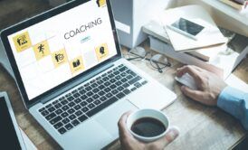 A man with his laptop taking the course on steps to launch an online coaching business.