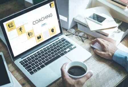 A man with his laptop taking the course on steps to launch an online coaching business.