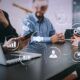 Business professionals collaborating on laptops, displaying visual management tools on their screens.