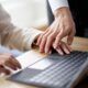 Two professionals on a laptop, highlighting the importance of workplace harassment prevention.