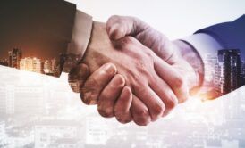 business professionals shaking hands with a city skyline in the background, symbolizing channel partnerships