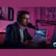 a man in a suit wearing headphones, seated at a desk, focused on how to start a podcast on spotify