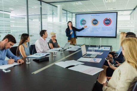 a woman presents a powerpoint to an audience, demonstrating effective presentation skills powerpoint