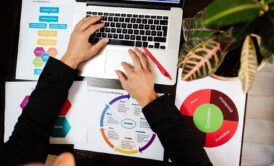 a person focused on a laptop displaying a business plan related to product management certification