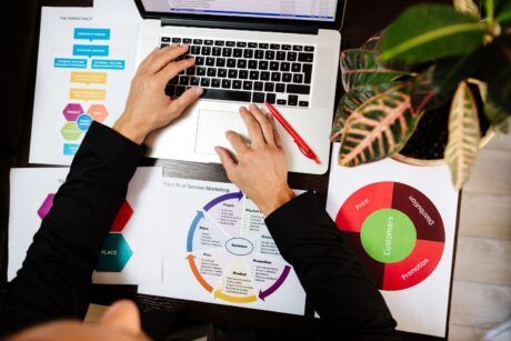 a person focused on a laptop displaying a business plan related to product management certification