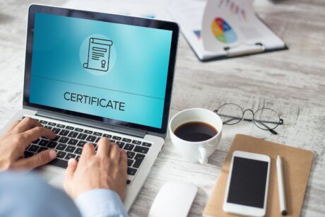 A man taking his Professional Scrum Master Certification exam on a laptop.