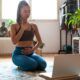 a woman seated on the floor with her laptop, embodying the art of meditation in a calm and peaceful setting